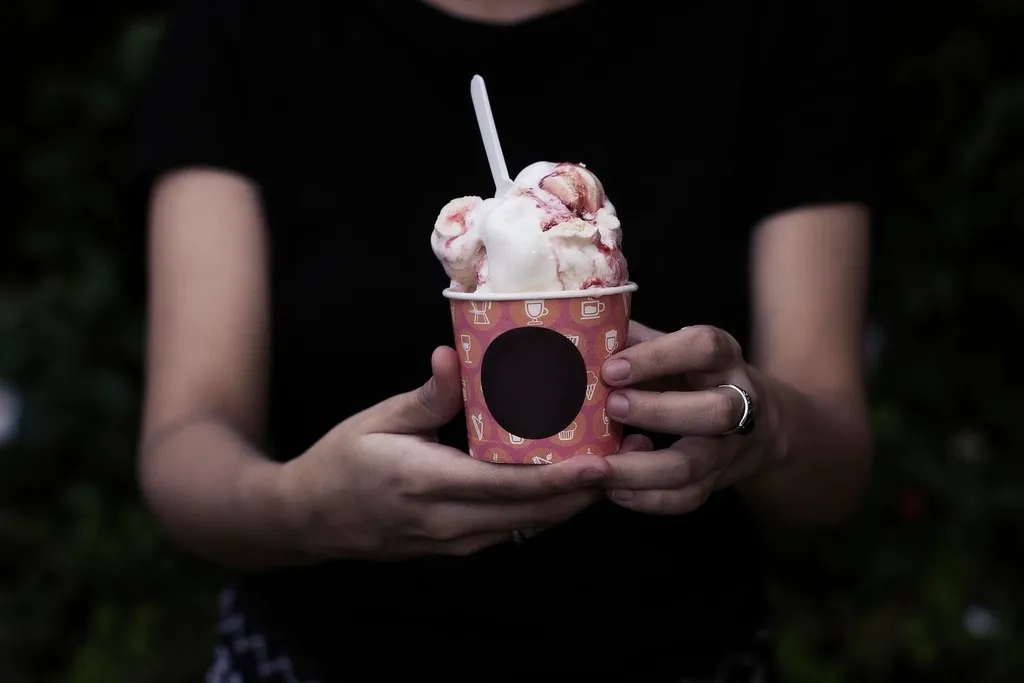 Hands holding a cup of strawberry gelato